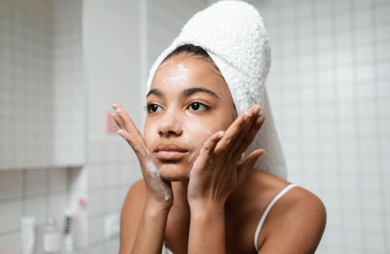 Femme nettoyant son visage dans le cadre d'une routine anti-taches quotidienne